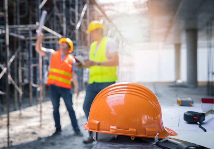 The yellow safety helmet in construction site and construction site worker background safety first concept.