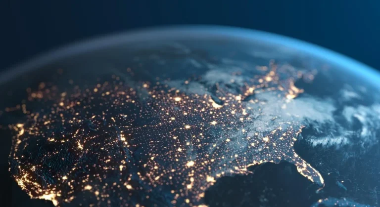 A view of North America from space at night, showing city lights illuminating densely populated areas across the continent against the dark curve of Earth.